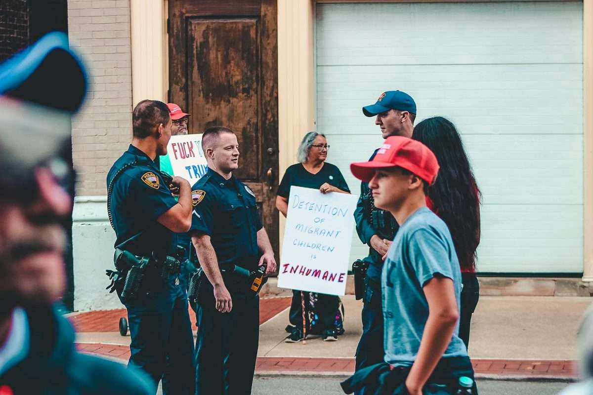 police standing near woman and man holding up signage